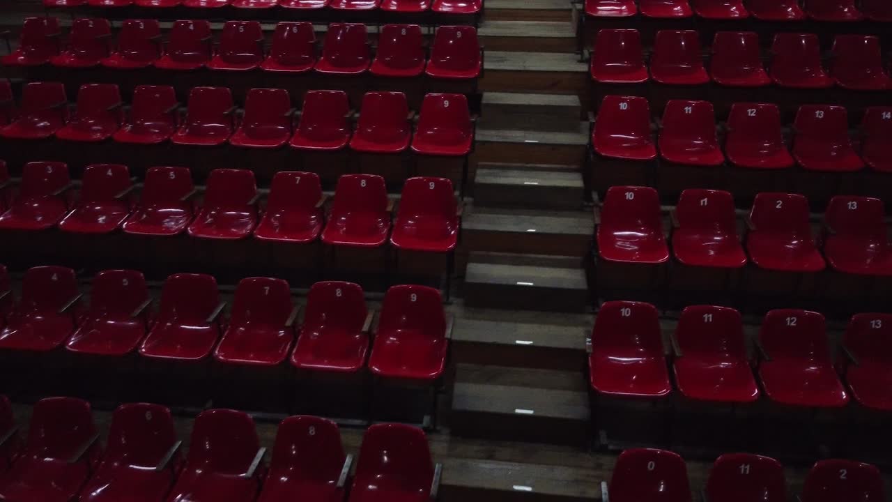 sala de teatro vacía, gradas rojas sin espectadores