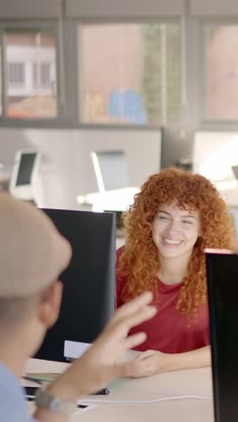 woman talking and laughing with a colleague in the office