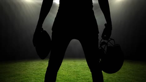 animation of silhouette of american football player holding helmet and ball over sports stadium