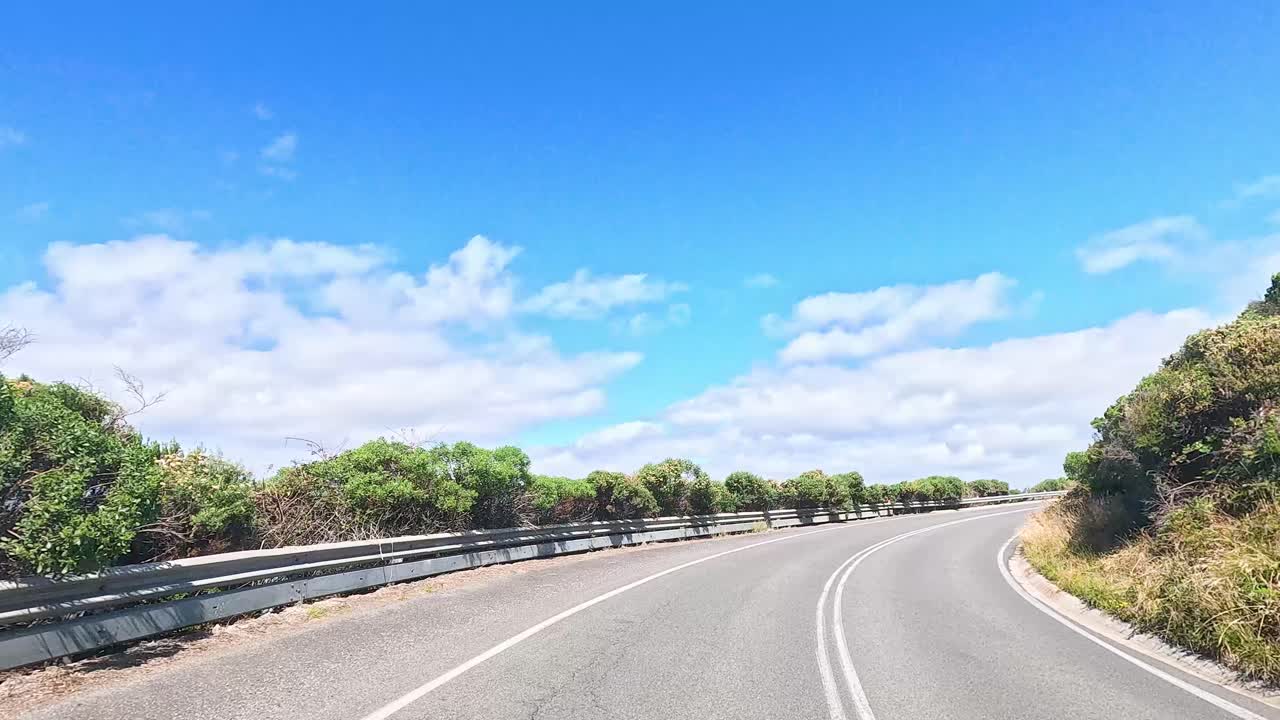 A 15-second video captures a sunny drive along the winding Great Ocean Road, showcasing lush greenery and ocean views
