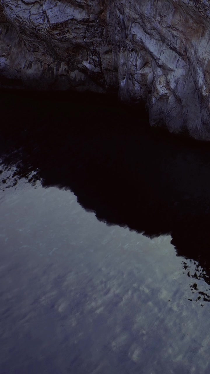 Wild coastline meets dark water at rocky shore