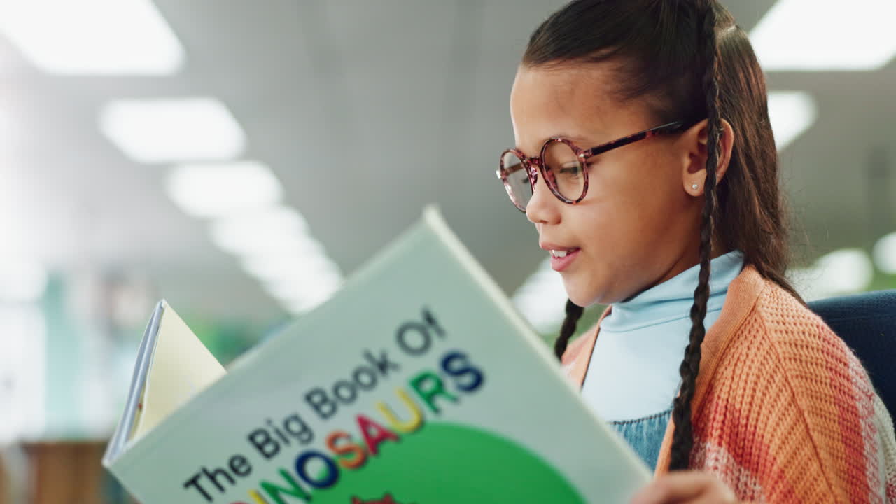 Girl reading The Big Book of Dinosaurs