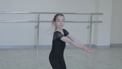 young ballerina practicing dance moves in studio