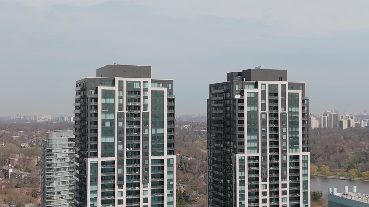 Toronto Parklawn condos with High Park and Lake Ontario in background on clear sunny day, medium establishing of buildings