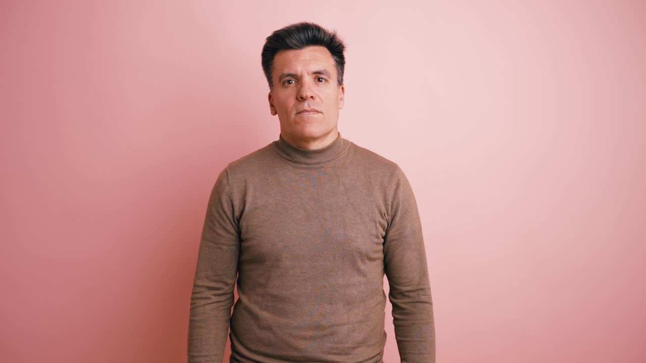 Middle-Aged Man Standing Still and Closing Eyes on Pink Background