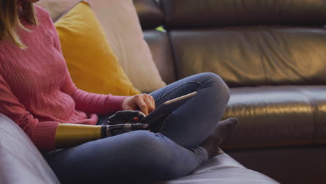 Close-Up-Of-Woman-With-Prosthetic-Arm-And-Hand-At-Home-Using-Digital-Tablet