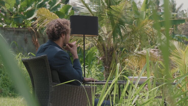 Thoughtful Man Working Under Palm Tree