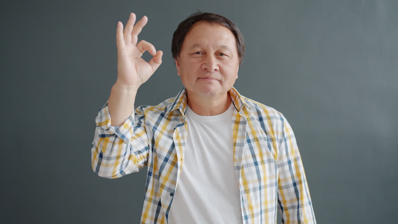 Older Asian Man Making Okay Gesture