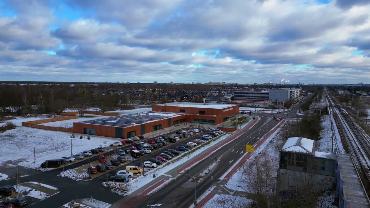 Indoor swimming pool with solar panels surrounded by snow and suburban homes in Falkensee Germany. Gorgeous aerial view flight pull in drone