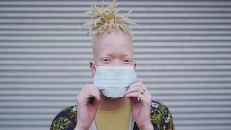 portrait of albino african american man with dreadlocks wearing face mask