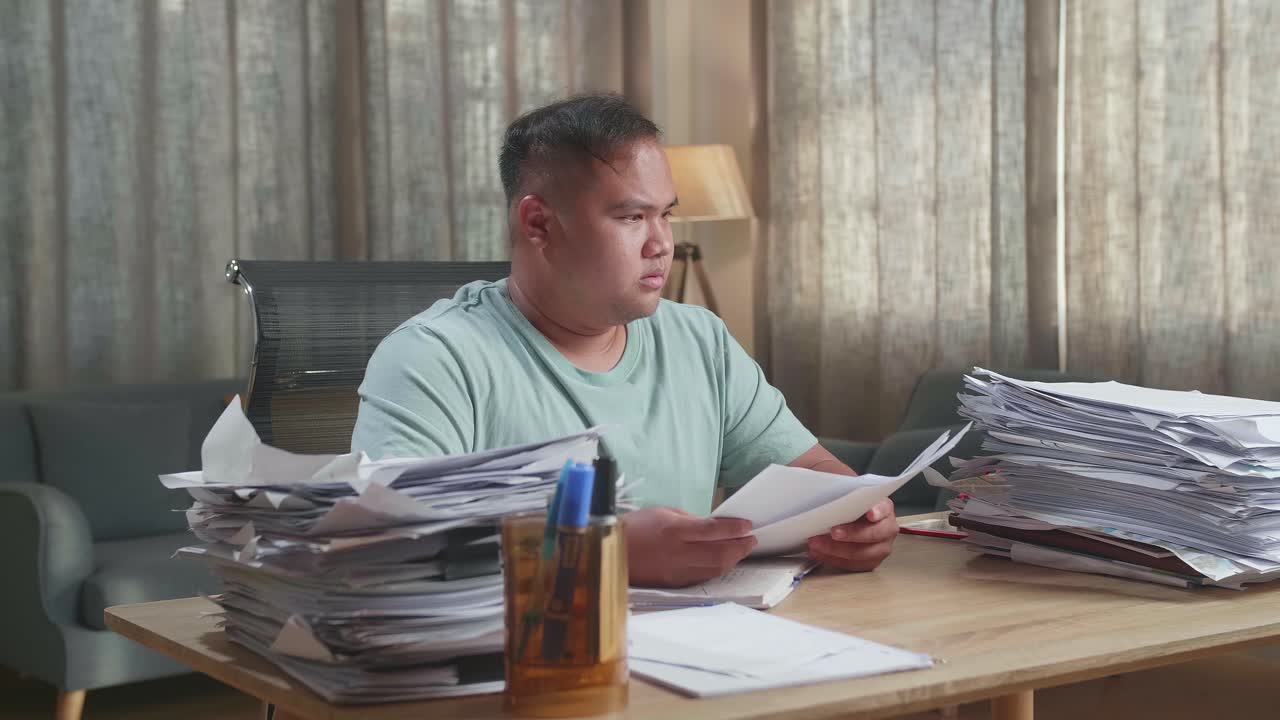 Fat Asian Man Being Tired Working Hard With Documents At The Office