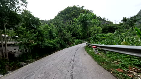 long winding road of ha-giang loop passing through lush mountains in northern vietnam. pov shot