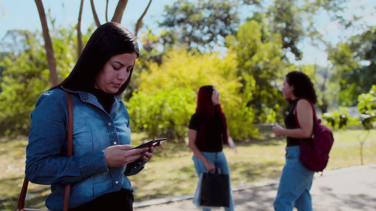 Young people using smartphones in a park setting