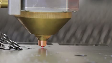 cnc laser cutting of metal, modern industrial technology. small depth of field. warning - authentic shooting in challenging conditions.
