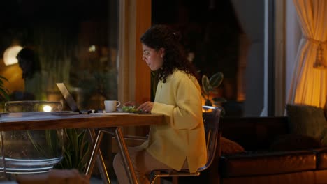mujer trabajando y cenando en casa por la noche