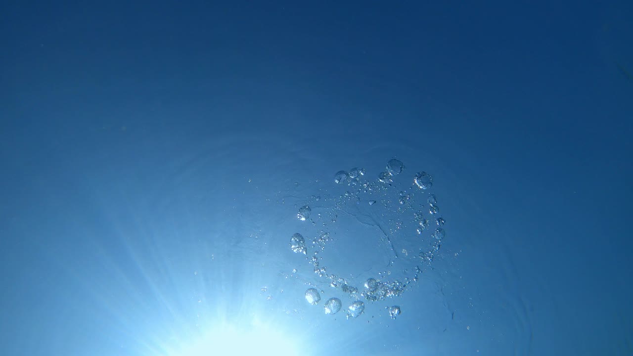 자유 다이버의 반지 거품과 파란 바다의 수중 표면.