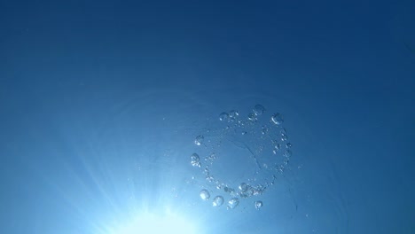 ring bubble by freediver and surface underwater in blue ocean. water texture.