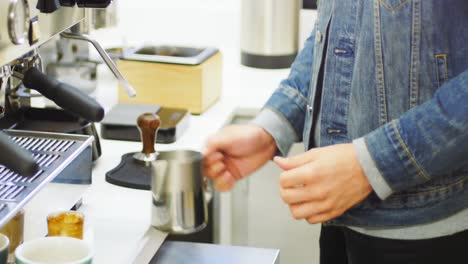 mid section of man making cup of coffee in kitchen