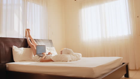 woman working on laptop in bed