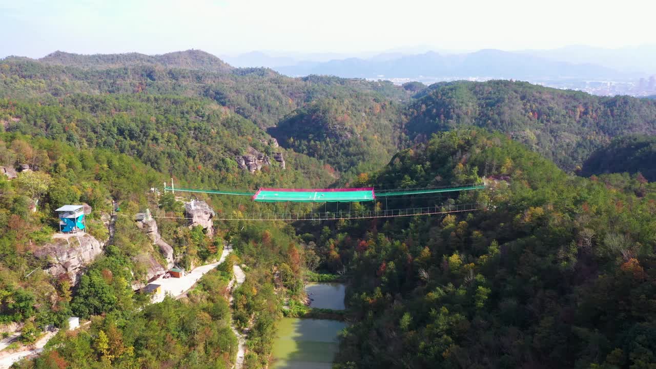 중국 제지안 지방의 시우안 마을 근처에 있는 협곡 위에 있는 서스펜션 축구장 (suspended football field) 의 공중 풍경: 울창한 숲이 인 언덕, 조용한 환경, 혁신적인 디자인이 숨막히는 장면을 만니다.