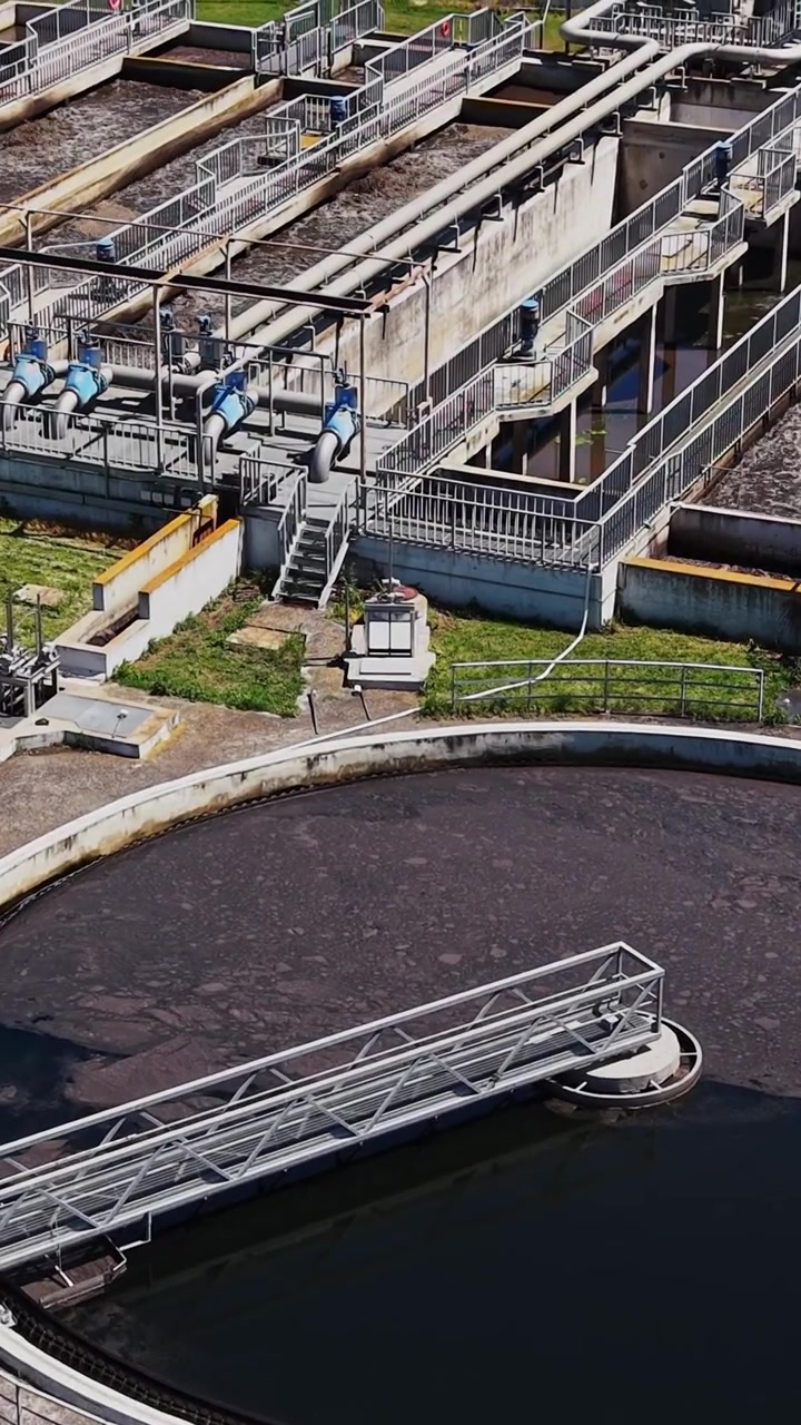 Planta de tratamiento de agua con grandes tanques circulares y áreas verdes
