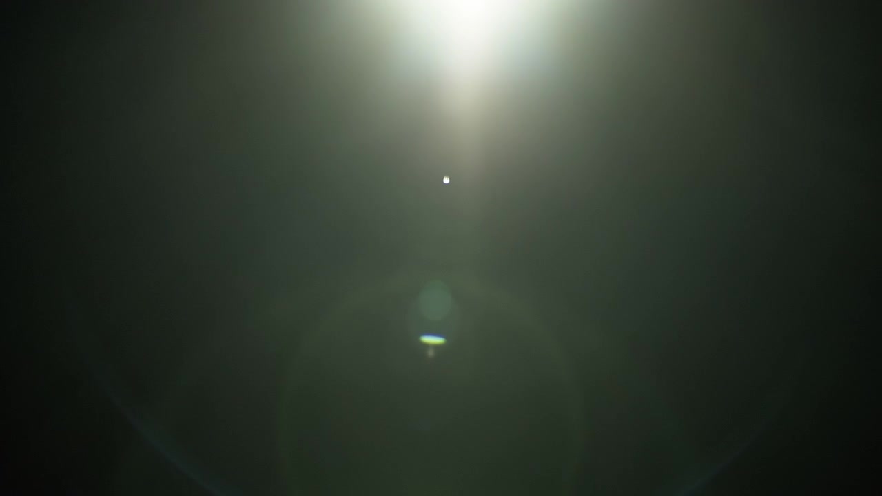 Reflexos de lente em um fundo preto para sobreposições ou transições. Câmera lenta