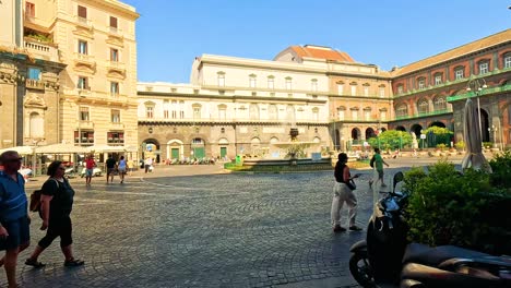 tourists and scooters in a bustling naples square