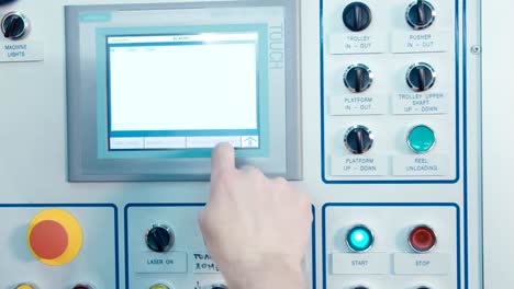 worker pushing buttons on a machine control panel with touch screen