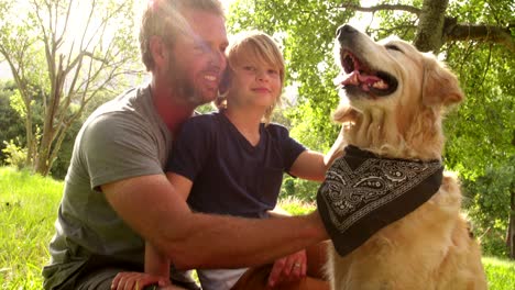 dad plays with his cute son and their dog outside