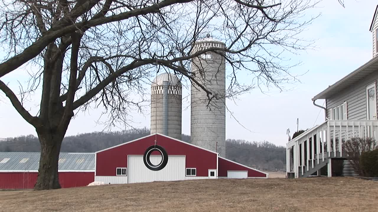 una granja completa con silos de graneros rojos y columpio de neumáticos para los niños