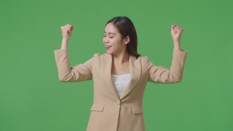 an asian business woman smile and flex muscle on green screen background in the studio