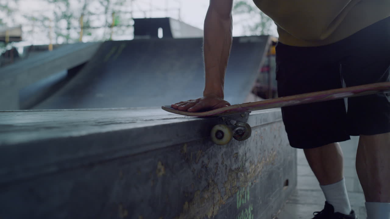manos de hombre tocando ruedas de patineta en el parque de patinaje. montando rueda de patineta.
