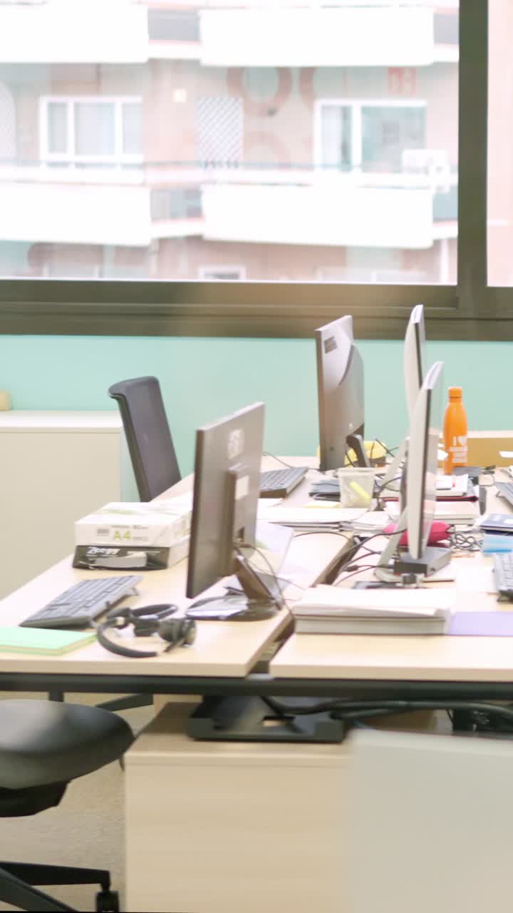 Empty coworking office with computers, stationary and chairs