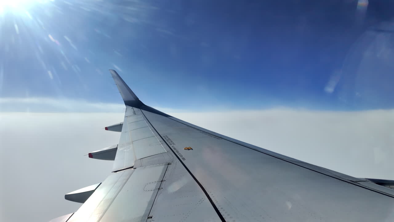 View from an airplane window of the aircraft wing in the clouds