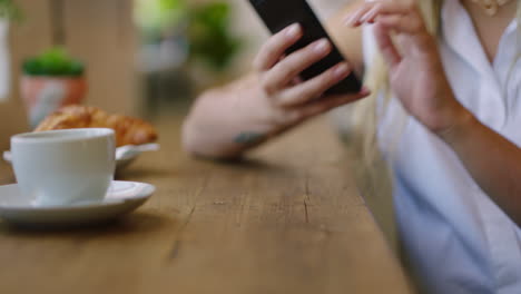 Woman,-hands-and-phone-in-cafe