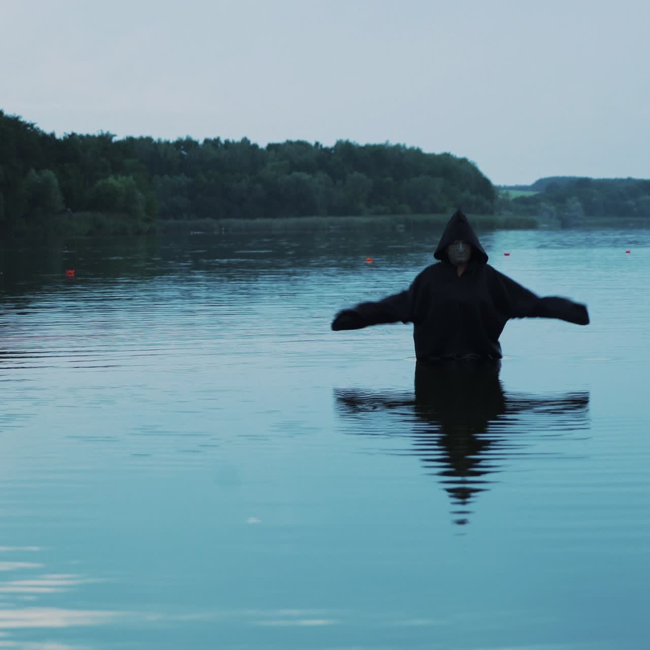 Horror woman soaking in water river. Scary figure in black mantle.