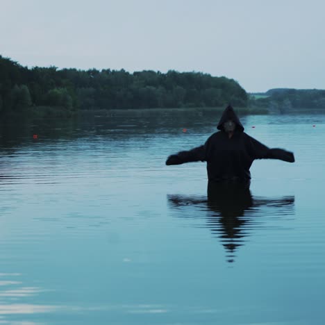 horror woman soaking in water river. scary figure in black mantle.