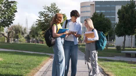 Young students discussing notes on university campus