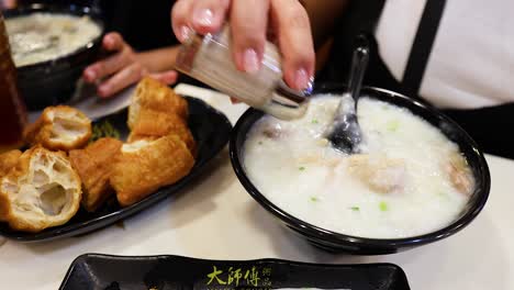 person eating congee and youtiao