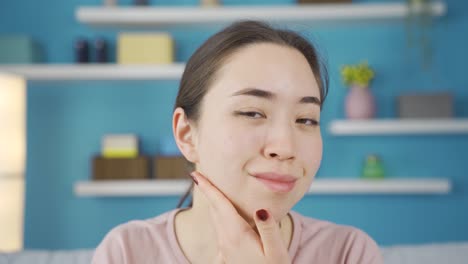 Close-up-portrait-of-Asian-young-woman-looking-at-her-skin-and-face.