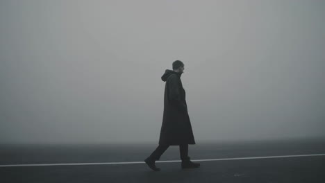 man walking through dense fog