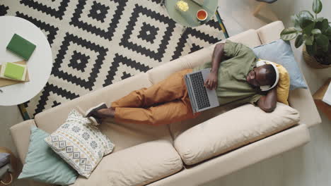 Black-Man-Listening-to-Music-with-Headphones-and-Using-Laptop