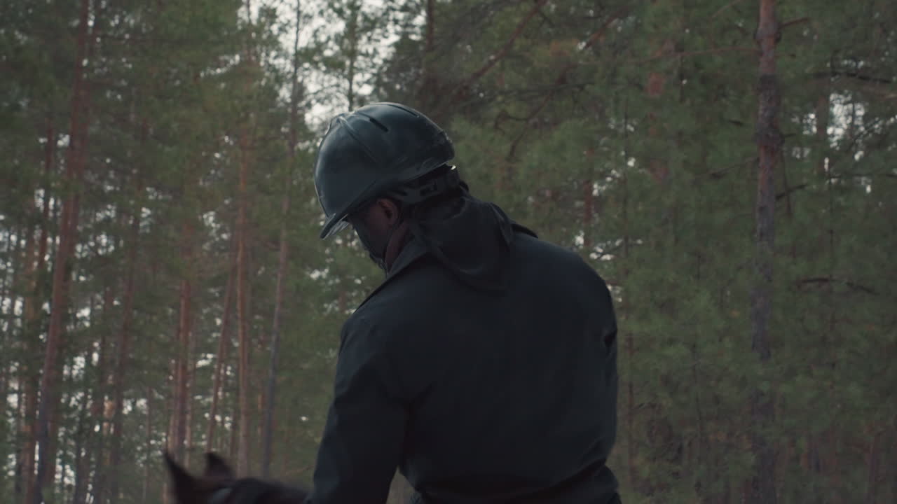 Erfaren rideguide, selvsikker rytter kontrollerer hest midt i et vinterligt fyrretræslandskab, ekspert i at holde tøjlerne stabile under kørsel gennem tæt fyrreskov