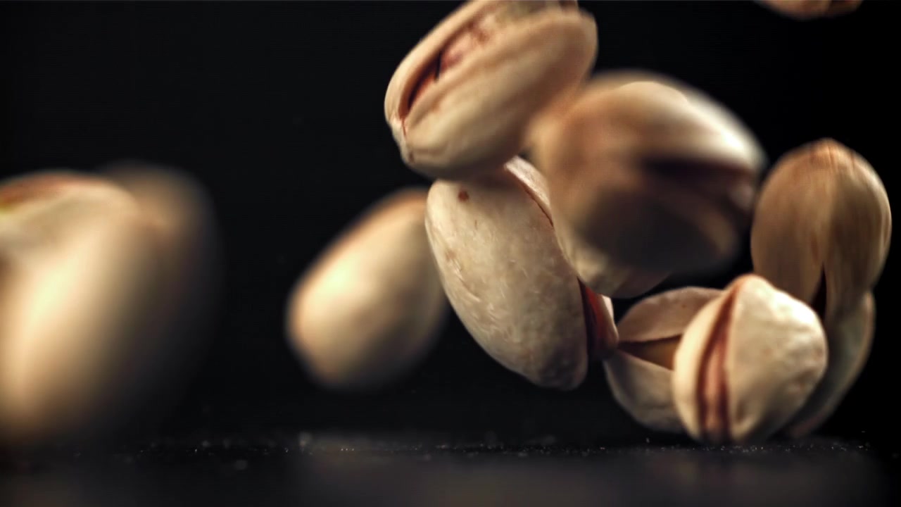 Pistachios Falling in Slow Motion Against a Black Background
