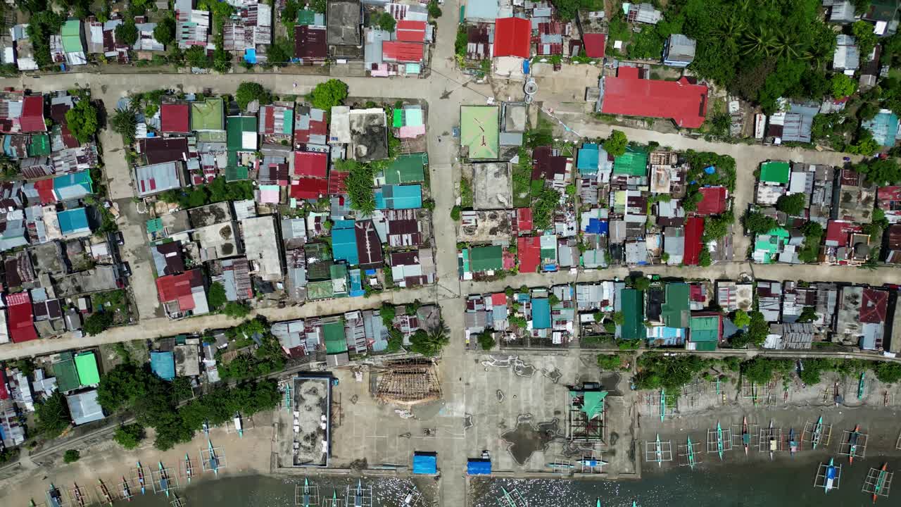 Top-Down Aerial Drone Shot of Colorful Coastal Barangay Layout with rooftops and boat docks in Codon, San Andres, Catanduanes, Philippines