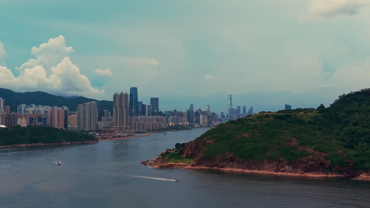 Drone shot of Hong Kong island and Kowloon near Victoria Harbour during a cloudy sunset day