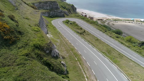 sports car taking a tight turn on the asphalt, drone aerial shot