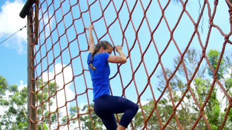 mujer subiendo una red durante el curso de obstáculos 4k