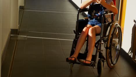 Disabled-schoolgirl-using-mobile-phone-in-the-corridor-4k
