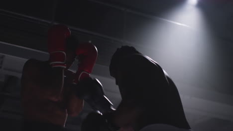 close up shot of two male boxers wearing gloves in boxing ring fighting in boxing match with low key lighting 7